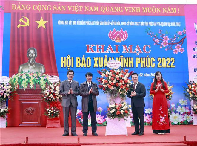 Chủ tịch Hội Nhà báo Việt Nam Lê Quốc Minh (thứ hai, phải) tặng hoa chúc mừng lãnh đạo Hội Nhà báo Việt Nam tỉnh Vĩnh Phúc. (Ảnh: Hoàng Hùng/TTXVN) Hội Báo Xuân Vĩnh Phúc: Tôn vinh văn hóa đọc, sự phát triển báo chí ảnh 1