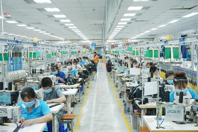 Công nhân làm việc tại TNHH may mặc Bowker Việt Nam, Khu công nghiệp Đồng An 1, thành phố Thuận An (Bình Dương). (Ảnh: Chí Tưởng/TTXVN) Doanh nghiệp ở Bình Dương cần tuyển dụng tới 50.000 lao động ảnh 1