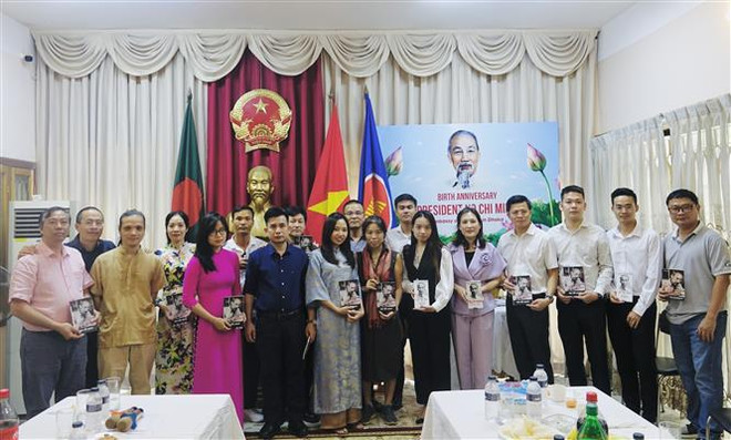 Lãnh đạo Đại sứ quán Việt Nam tại Bangladesh trao tặng bà con Việt Nam các tác phẩm về Bác. (Ảnh: TTXVN phát) Người Việt tại Bangladesh kỷ niệm ngày sinh Chủ tịch Hồ Chí Minh ảnh 1