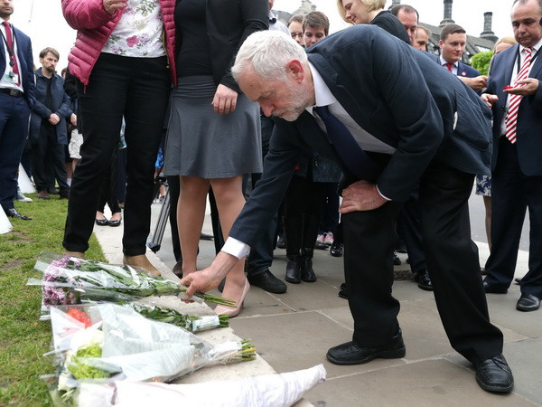 Thủ lĩnh Công đảng Anh Jeremy Corbyn (giữa) đặt hoa tưởng niệm nữ nghị sỹ Jo Cox tại thủ đô London ngày 16/6. (Nguồn: AFP/TTXVN) Anh nối lại phong trào vận đông cử tri bỏ phiếu rời hay ở lại EU ảnh 1