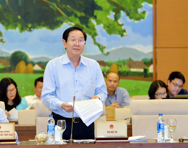 Bộ trưởng Bộ Nội vụ Lê Vĩnh Tân trình bày tờ trình. (Ảnh: Trọng Đức/TTXVN) Băn khoăn việc giảm số Phó Chủ tịch HĐND cấp tỉnh, huyện ảnh 1