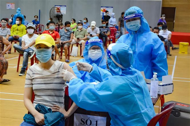 Nhân viên y tế tiêm vaccine ngừa COVID-19 cho người dân tại Cung thể thao Tiên Sơn, thành phố Đà Nẵng. (Ảnh: Văn Dũng/TTXVN) Đà Nẵng: Thêm điểm tiêm vaccine để tránh tập trung đông người ảnh 1