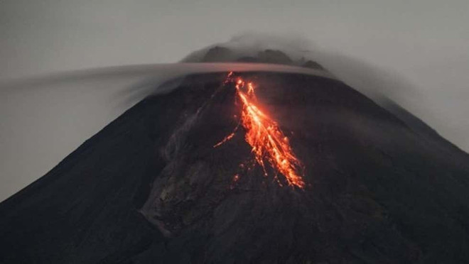Bức ảnh chụp vào ngày 5/3/2021, cho thấy vật chất phun ra từ núi lửa Merapi, nhìn từ làng Tunggul Arum, quận Sleman ở Yogyakarta, Indonesia. (Nguồn: weather.com) Núi lửa Merapi của Indonesia lại phun trào khí nóng, lan xa 2km ảnh 1