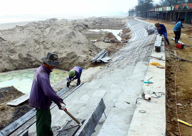 Công nhân đang gấp rút thi công dự án đường dạo bộ và bờ kè dài hơn 1km tại thị xã Cửa Lò để phục vụ mùa du lịch 2022. (Ảnh: Tá Chuyên/TTXVN) Nghệ An: Thị xã Cửa Lò chỉnh trang đô thị đón du khách trở lại ảnh 3