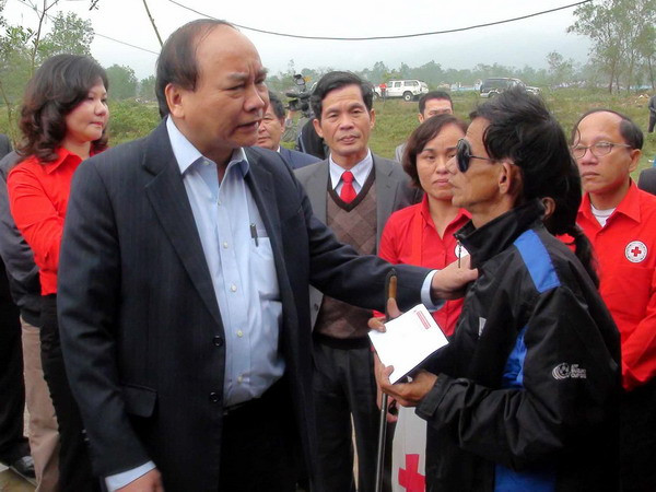 Phó Thủ tướng Nguyễn Xuân Phúc thăm, tặng quà cho ông Hồ Kiềng, 50 tuổi, bị mù, ở xã Lộc Tiến, huyện Phú Lộc. (Ảnh: Quốc Việt/TTXVN) Phó Thủ tướng tặng quà Tết người nghèo tại Thừa Thiên-Huế ảnh 1