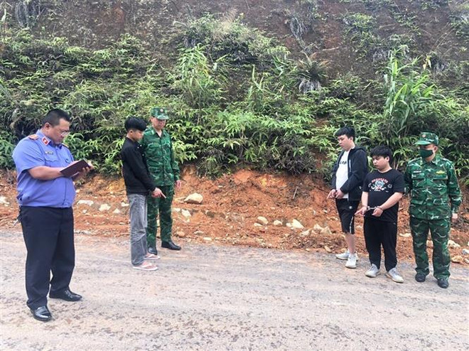 Các đối tượng bị lực lượng Bộ đội Biên phòng tỉnh Quảng Ninh bắt giữ khi đang bỏ trốn. (Ảnh: TTXVN phát) Biên phòng Quảng Ninh bắt năm đối tượng tổ chức nhập cảnh trái phép ảnh 2