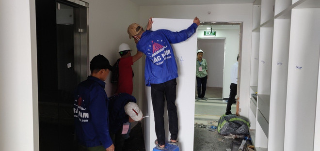 Lực lượng cưỡng chế tháo dỡ các thiết bị tại tầng 18 tòa nhà vi phạm trật tự xây dựng tại 8B Lê Trực. (Nguồn: TTXVN phát) Hà Nội cơ bản tháo dỡ xong thiết bị bên trong tầng 18 nhà 8B Lê Trực ảnh 1