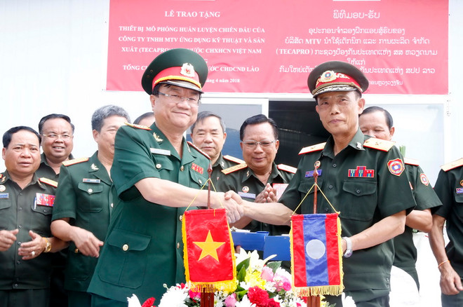 Đại tá Lê Việt, Giám đốc Công ty Tecapro, Bộ Quốc phòng Việt Nam (trái) và Kilakon Bounnaphon, Tổng Cục trưởng, Tổng Cục kỹ thuật Quân đội nhân dân Lào (phải) trao Biên bản Bàn giao Trung tâm mô phỏng huấn luyện chiến đấu tại buổi lễ. (Ảnh: Phạm Kiên/Vietnam+) Việt Nam bàn giao trung tâm mô phỏng chiến đấu cho quân đội Lào ảnh 1
