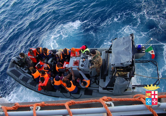 Những người nhập cư được hải quân Italy cứu trên biển. (Nguồn: AFP/TTXVN) Vụ đắm tàu ngoài khơi Italy: Ít nhất 14 người thiệt mạng ảnh 1