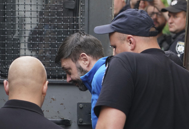 Ông Kirill Vyshinskiy, người đứng đầu văn phòng hãng tin RIA Novosti của Nga tại Ukraine, được hộ tống từ một phòng xử án ở Kiev, Ukraine, ngày 15/7/2019. (Nguồn: AP) Nga và Ukraine đẩy nhanh thỏa thuận trao đổi tù nhân ảnh 1