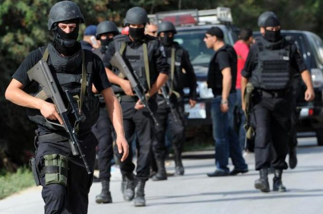 Nhân viên an ninh Tunisia gác bên ngoài ngôi nhà nơi các tay súng vũ trang dùng làm căn cứ ở Oud Ellil. (Nguồn: AFP) Tunisia: Lực lượng an ninh và phiến quân giao tranh gần thủ đô ảnh 1