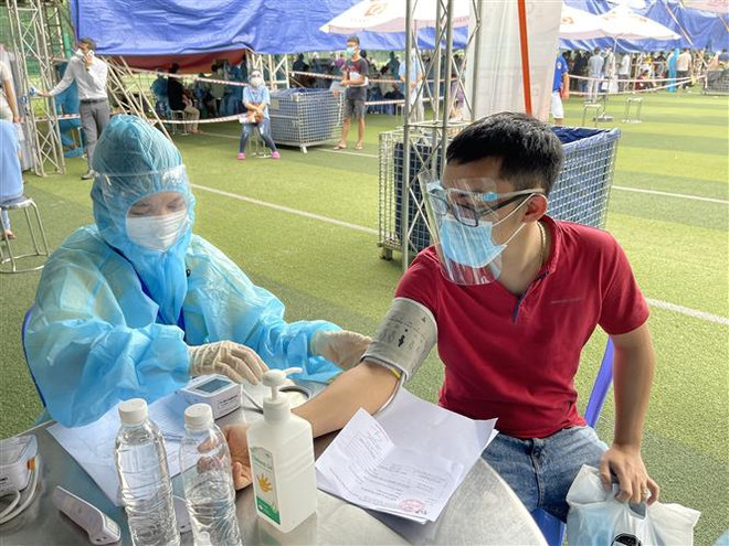 Tiêm vaccine phòng COVID-19 cho người lao động trong doanh nghiệp tại Bình Dương. (Ảnh: Huyền Trang/TTXVN) Bình Dương vẫn còn 10.365 bệnh nhân đang điều trị COVID-19 ảnh 1