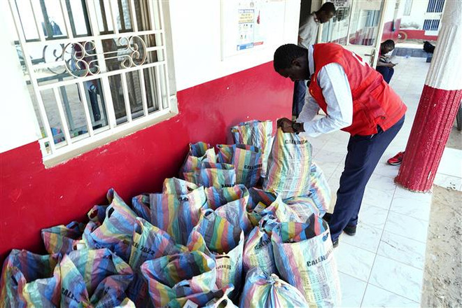 Nhân viên Chữ thập đỏ Gambia kiểm tra số siro ho thu giữ tại Banjul, ngày 6/10/2022. (Ảnh: AFP/TTXVN) Gambia thu hồi thêm các loại thuốc nghi khiến trẻ em tử vong ảnh 1