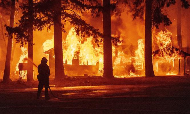 Nhân viên cứu hỏa nỗ lực khống chế các đám cháy rừng tại hạt Plumas, bang California (Mỹ), ngày 25/7/2021. (Ảnh: AFP/TTXVN) Mỹ: Cháy rừng tạo ra hình thái thời tiết riêng tại California ảnh 1