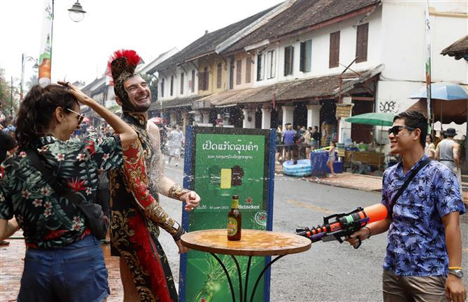 Du khách đến từ Italy vui mừng tham gia lễ hội té nước. (Ảnh: Phạm Kiên/TTXVN) Người dân Lào đồng loạt tổ chức hoạt động chào mừng năm mới ảnh 1