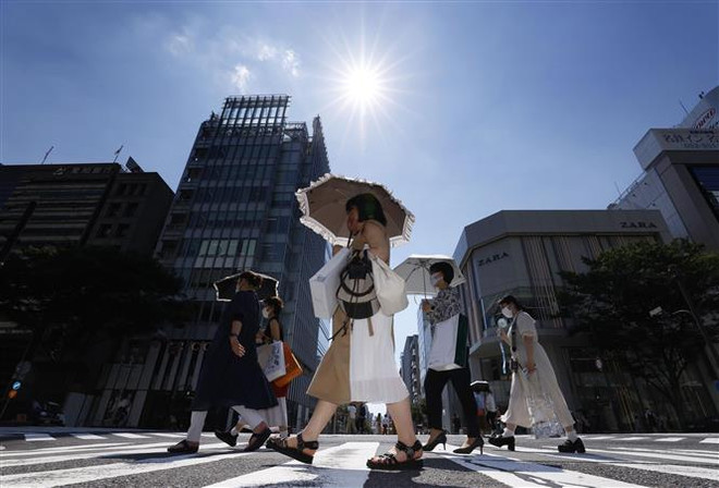Người dân di chuyển dưới tiết trời nắng nóng tại Nagoya (Nhật Bản). (Ảnh: Kyodo/TTXVN) Nhật Bản thông qua kế hoạch giảm một nửa số ca tử vong do nắng nóng ảnh 1