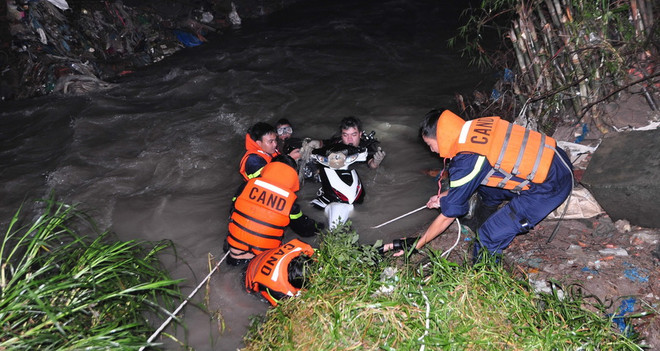 Đi xe máy qua cầu giữa đêm mưa, hai người đàn ông bị nước cuốn trôi ảnh 1