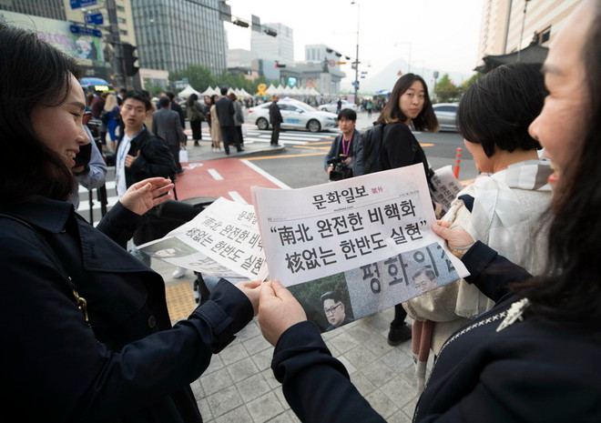 Người dân Hàn Quốc đọc báo về hội nghị thượng đỉnh liên Triều tại Seoul, Hàn Quốc ngày 27/4. (Nguồn: Yonhap/TTXVN) Hơn 60% dân Hàn Quốc tin vào thiện chí phi hạt nhân hóa của Triều Tiên ảnh 1