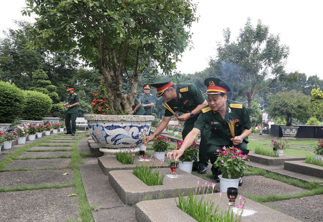 Các đại biểu thắp hương tại các mộ phần Anh hùng Liệt sỹ tại Nghĩa trang Liệt sỹ Thành phố Hồ Chí Minh. (Ảnh: Thanh Vũ/TTXVN) ngay thuong binh liet sy 2.jpeg