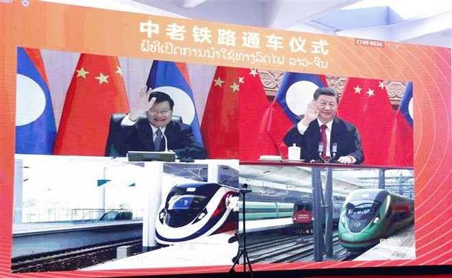 Lãnh đạo Lào và Trung Quốc vẫy tay chào hai đoàn tàu đang xuất phát khỏi ga Vientiane và ga Côn Minh, trong lễ khánh thành tuyến đường sắt Trung Quốc-Lào ngày 3/12/2021. (Ảnh: Phạm Kiên/TTXVN) Chuyến tàu hàng đầu tiên giữa tỉnh Sơn Tây của Trung Quốc và Lào ảnh 1