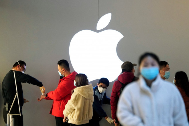 Khách hàng đeo khẩu trang và được kiểm tra thân nhiệt trong một cửa hàng Apple, ở Thượng Hải, Trung Quốc, ngày 21/2. (Nguồn: Reuters) Apple mở lại hơn một nửa số cửa hàng bán lẻ tại Trung Quốc ảnh 1