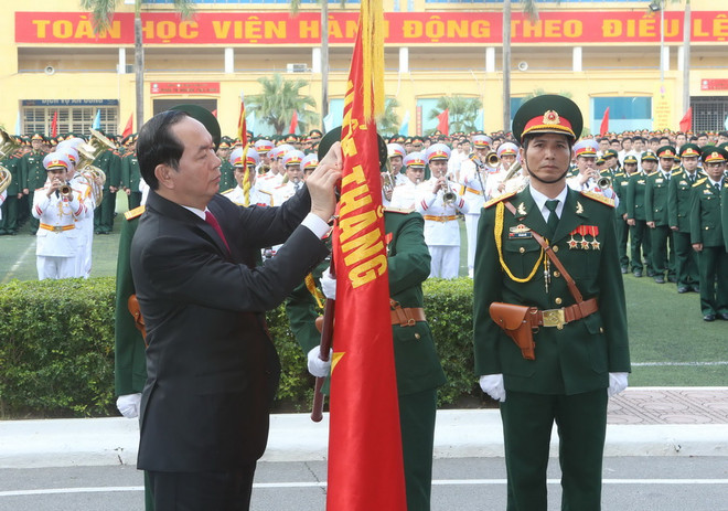 Chủ tịch nước Trần Đại Quang gắn Huân chương Độc lập hạng Nhì lên cờ truyền thống của Học viện. (Ảnh: Nhan Sáng/TTXVN) Chủ tịch nước trao tặng huân chương cho Học viện Kỹ thuật Quân sự ảnh 1