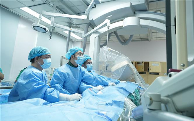 Các bác sỹ Bệnh viện Đại học Y dược thực hiện phẫu thuật thay van động mạch phổi qua da cho người bệnh. (Ảnh: TTXVN phát) TP.HCM: Triển khai thành công kỹ thuật thay van động mạch phổi qua da ảnh 3