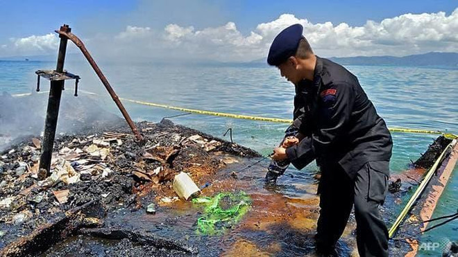 Cảnh sát trên con tàu chở khách bị cháy, chìm dưới nước. (Nguồn: AFP) Indonesia huy động quân đội, cảnh sát tìm nạn nhân vụ cháy tàu khách ảnh 1