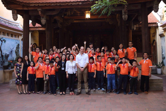Hoàng tử Anh chụp ảnh lưu niệm với các học sinh trường Tiểu học Hồng Hà. (Ảnh: Minh Sơn/Vietnam+) Hoàng tử Anh tặng sách bảo vệ tê giác cho 1,5 triệu học sinh Việt Nam ảnh 3