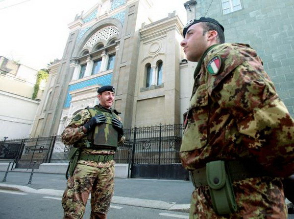 Hai lính quân đội Italy canh gác phía trước một giáo đường Do thái giáo ở Milan. (Nguồn: Corriere della Sera) Italy thông qua sắc lệnh đặc biệt tăng cường chống khủng bố ảnh 1