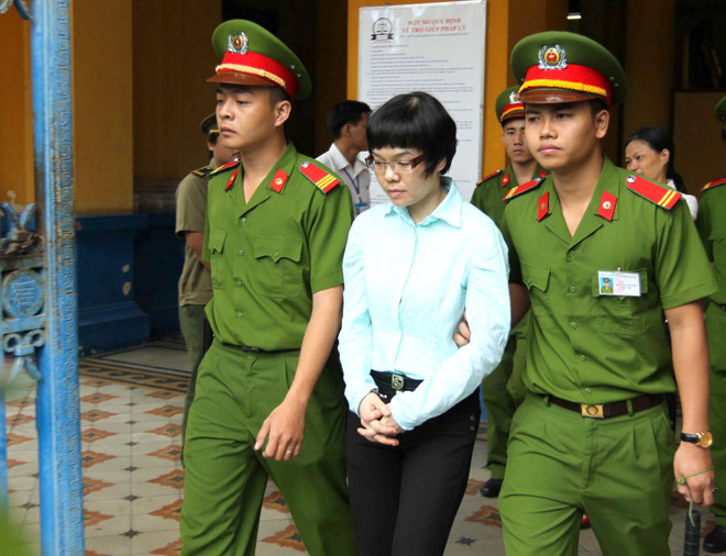Cảnh sát áp giải Huỳnh Thị Huyền Như sau phiên tòa sơ thẩm tháng 1/2014. (Ảnh: Thanh Vũ/TTXVN) Xét xử phúc thẩm vụ án Huỳnh Thị Huyền Như cùng đồng phạm ảnh 1