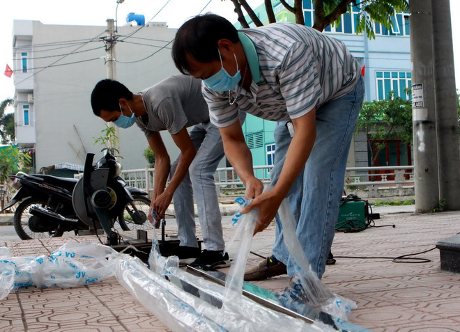Người dân sống 2 bên bờ sông phải đeo khẩu trang khi làm việc vì mùi hôi thối bốc lên từ dòng sông. (Ảnh: Thế Duyệt/TTXVN) Gần 2.000 người dân khốn khổ sống bên cạnh dòng sông ô nhiễm, bốc mùi ảnh 3