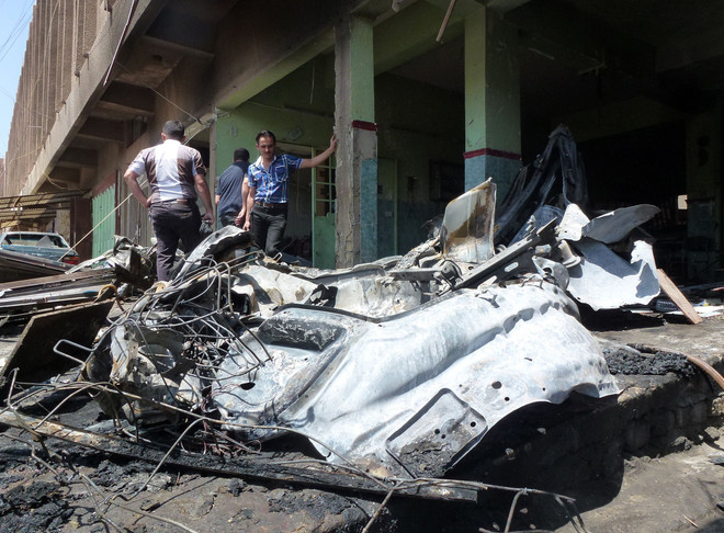 Hiện trường một vụ đánh bom xe ở quận Karrada, Baghdad ngày 13/5. (Nguồn: AFP/TTXVN) Vụ đánh bom liên hoàn ở Iraq: Hơn 100 người thương vong ảnh 1