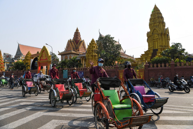 Người dân đeo khẩu trang phòng lây nhiễm COVID-19 trên một đường phố ở Phnom Penh, Campuchia, ngày 30/3/2020. (Nguồn: AFP/TTXVN) Campuchia chuẩn bị cách ly hơn 15.000 công nhân tại Phnom Penh ảnh 1
