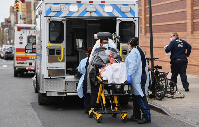 Nhân viên y tế chuyển bệnh nhân nhiễm COVID-19 lên xe cứu thương tới bệnh viện ở New York, Mỹ, ngày 7/4/2020. (Nguồn: AFP/TTXVN) Số ca tử vong do mắc COVID-19 tại Mỹ vượt mốc 32.000 người ảnh 1
