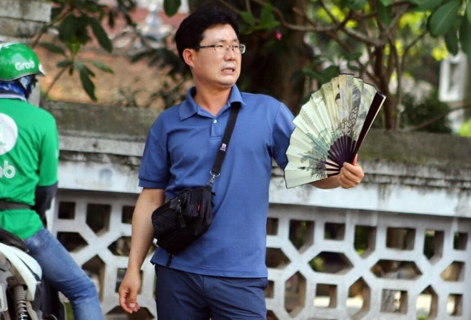 Một khách nước ngoài khó chịu với thời tiết nắng nóng tại Thủ đô Hà Nội. (Ảnh: Danh Lam/TTXVN) Nắng nóng gay gắt tiếp tục ở Bắc Bộ và Trung Bộ, nhiệt độ hơn 40 độ C ảnh 1