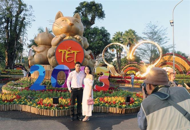 Nhiều du khách lưu lại khoảnh khắc đẹp bên người thân tại đường hoa Xuân Tuy Hòa. (Ảnh: Xuân Triệu/TTXVN) Nhiều tín hiệu vui đầu Xuân cho sự phục hồi của ngành du lịch Phú Yên ảnh 2