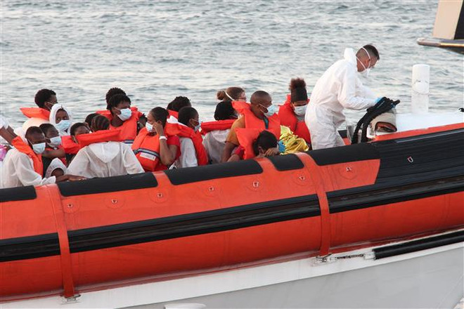 Người di cư được lực lượng thực thi pháp luật Italy giải cứu trên biển và đưa về cảng trên đảo Lampedusa, miền Nam Italy. (Ảnh: AFP/TTXVN) Liên tiếp xảy ra đắm thuyền chở người di cư ngoài khơi Italy ảnh 1