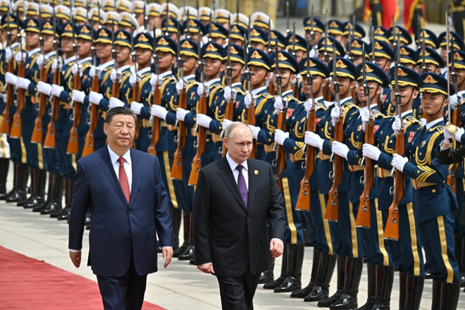 Chủ tịch Trung Quốc Tập Cận Bình (trái) và Tổng thống Nga Vladimir Putin duyệt đội danh dự tại lễ đón ở Bắc Kinh ngày 16/5/2024. (Ảnh: AFP/TTXVN) nga_trung 3.jpg