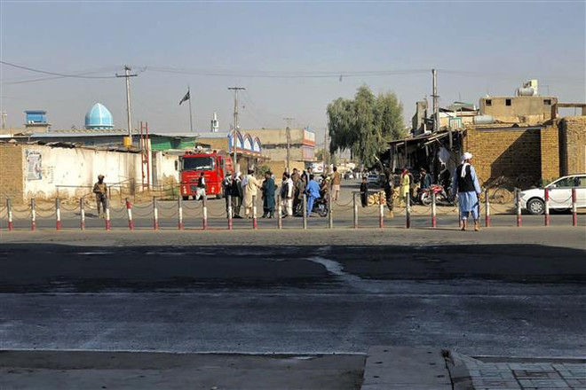 Các thành viên Taliban gác gần hiện trường vụ nổ tại thánh đường Hồi giáo ở thành phố Kandahar của Afghanistan, ngày 15/10/2021. (Ảnh: AFP/TTXVN) Taliban cam kết tăng cường an ninh sau vụ tấn công ở Kandahar ảnh 1