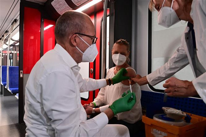 Nhân viên y tế tiêm vaccine ngừa COVID-19 cho người dân tại Berlin (Đức). (Ảnh: AFP/TTXVN) Đức: Frankfurt có thể cấm người chưa tiêm chủng vào siêu thị ảnh 1