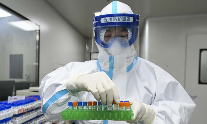 Một nhân viên y tế xử lý các mẫu xét nghiệm axit nucleic tại Phòng thí nghiệm y tế ở Trường Sa, Trung Quốc. (Nguồn: Getty Images) Trung Quốc công bố dữ liệu gene của virus SARS-CoV-2 ảnh 1