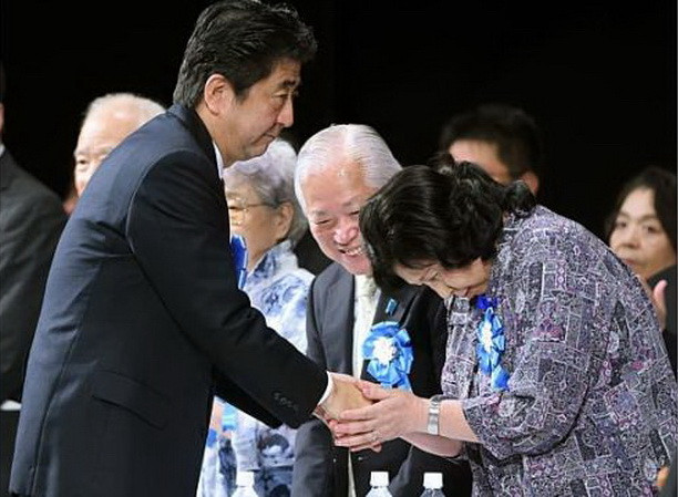 Thủ tướng Nhật Bản Shinzo Abe (trái) bắt tay nạn nhân vụ bắt cóc Hitomi Soga (bên phải) trong buổi míttinh hỗ trợ gia đình nạn nhân vụ bắt cóc diễn tại Tokyo, tháng 9/2014. (Nguồn AFP) Triều Tiên cam kết đẩy mạnh điều tra vụ bắt cóc công dân Nhật ảnh 1