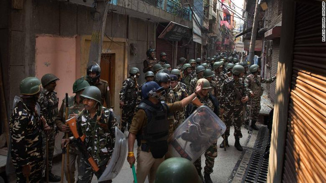 Cảnh sát vũ trang triển khai tại một địa điểm xảy ra xung đột ở New Delhi. (Nguồn: CNN) Bạo lực cộng đồng tại Ấn Độ: Nga cảnh báo công dân thận trọng ảnh 1