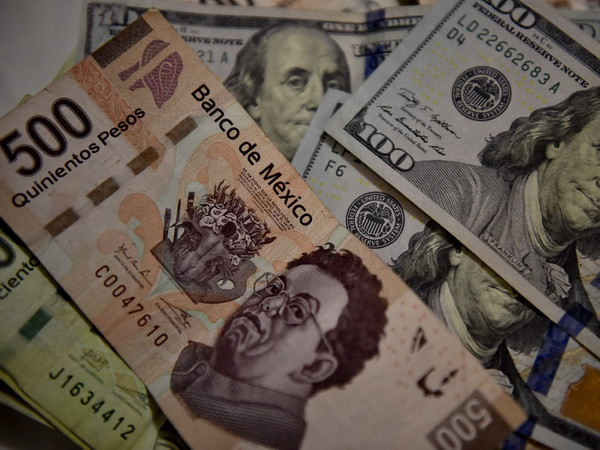 Đồng đôla Mỹ và đồng peso của Mexico. (Nguồn: AFP/TTXVN) Chiến thắng của ông Donald Trump tác động mạnh tới kinh tế châu Mỹ ảnh 1