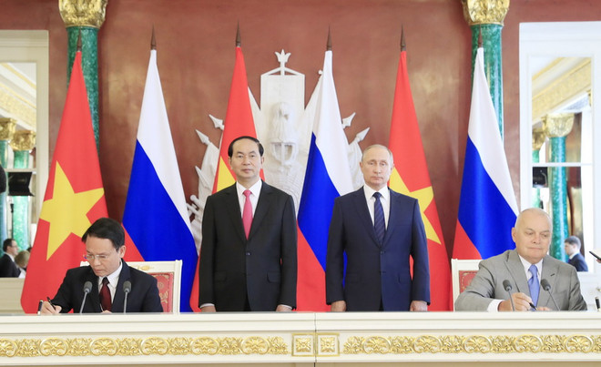 Chủ tịch nước Trần Đại Quang và Tổng thống Liên bang Nga V. Putin chứng kiến Lễ ký Thỏa thuận hợp tác giữa Thông tấn xã Việt nam và Hãng thông tấn Sputnik. (Ảnh: Nhan Sáng/TTXVN) Thông tấn xã Việt Nam ký thỏa thuận trao đổi thông tin với Sputnik ảnh 1