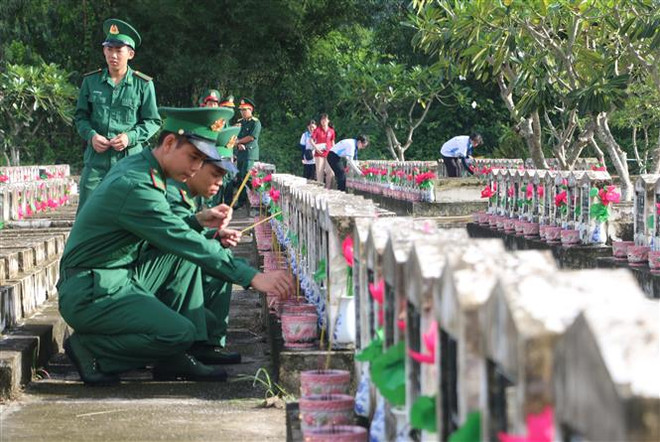 Đoàn viên thanh niên Lực lượng Vũ trang dâng hương lên các phần mộ Liệt sỹ tại Nghĩa trang Liệt sỹ Dốc Bà Đắc, xã Thới Sơn, thị xã Tịnh Biên (tỉnh An Giang). (Ảnh: Công Mạo/TTXVN) Tháng Bảy về thăm “Nghĩa trang Trường Sơn” ở biên giới Tây Nam ảnh 1