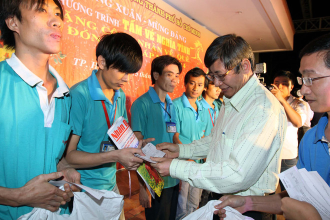 Phó Chủ tịch Thường trực Tổng Liên đoàn Lao Động Việt Nam Nguyễn Thanh Hải trao vé xe và quà Tết Giáp Ngọ 2014 cho công nhân khu chế xuất Linh Trung, Thủ Đức. (Ảnh: Thanh Vũ/TTXVN) Những chuyến xe nghĩa tình với công nhân về quê đón Tết ảnh 1