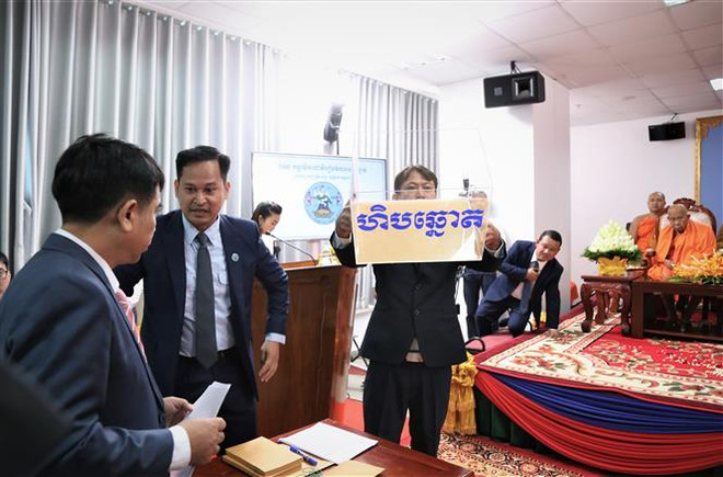 Các quan chức và nhân viên Ủy ban Bầu cử Quốc gia Campuchia giới thiệu thùng phiếu tại lễ bốc thăm. (Ảnh: Huỳnh Thảo/TTXVN) Campuchia bốc thăm, xếp thứ tự các chính đảng tham gia tổng tuyển cử ảnh 1