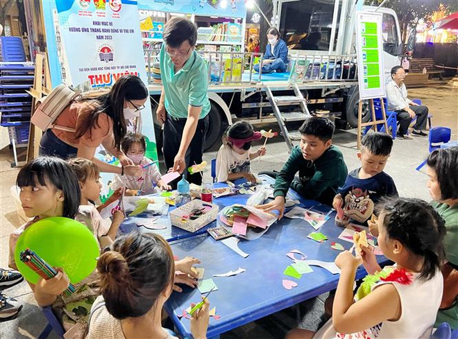 Nhiều hoạt động dành cho thiếu nhi tại khu vực thư viện lưu động. (Ảnh: Thu Hương/TTXVN) Tạo môi trường lành mạnh để trẻ em phát triển toàn diện ảnh 3